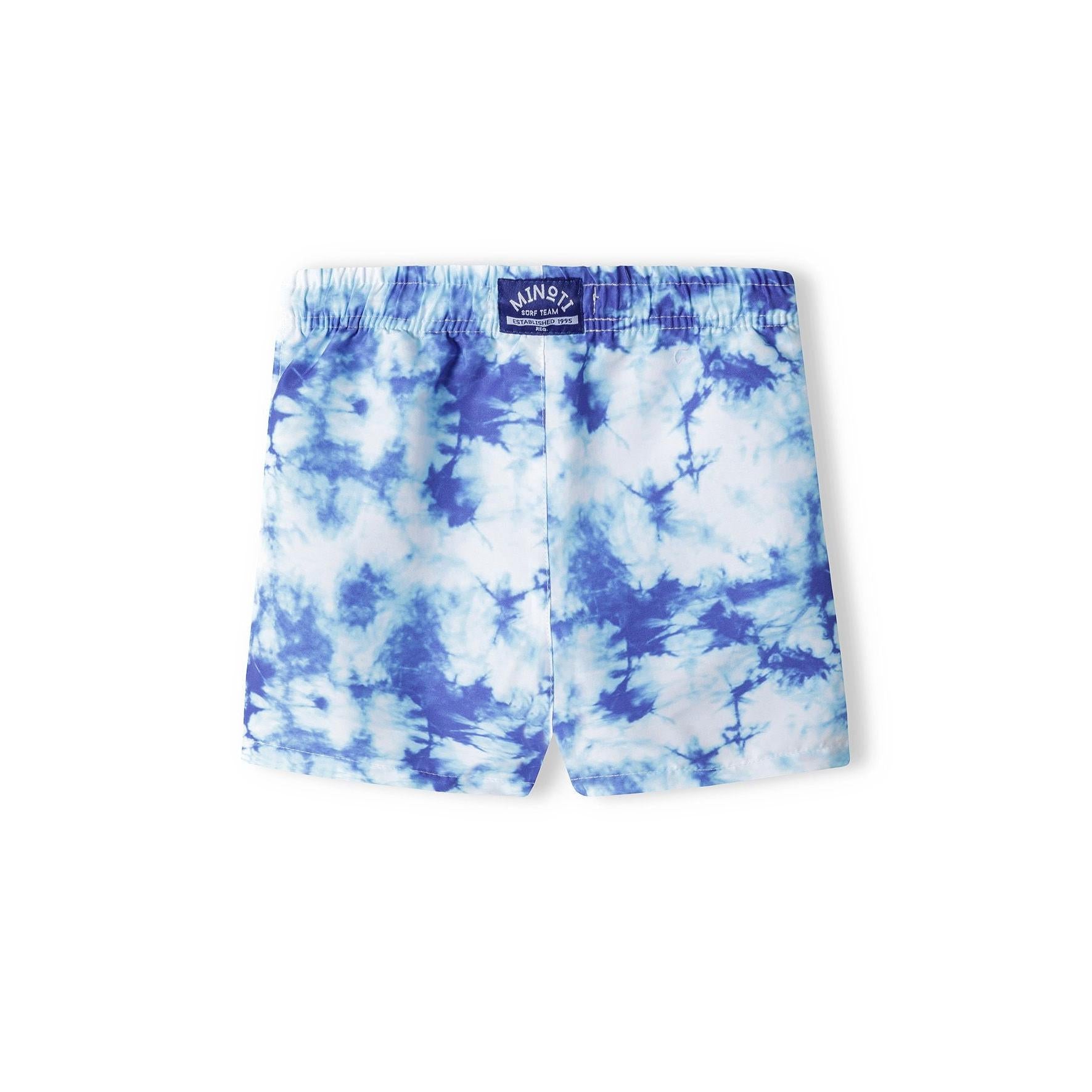 Back view of blue tie-dye board shorts showing Minoti brand label and continuation of cloud pattern