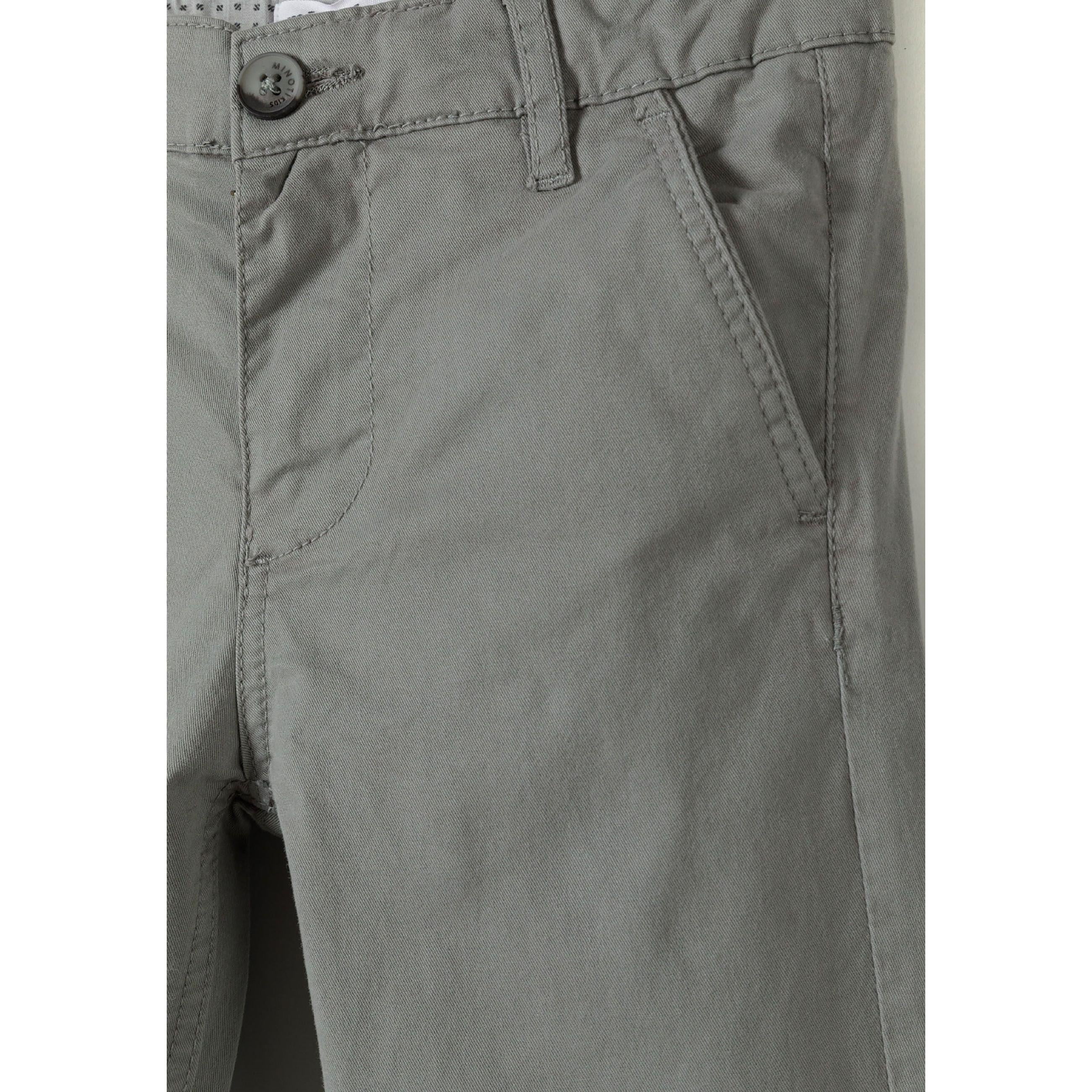 Close-up detail of grey chino waistband showing button closure and front pocket construction