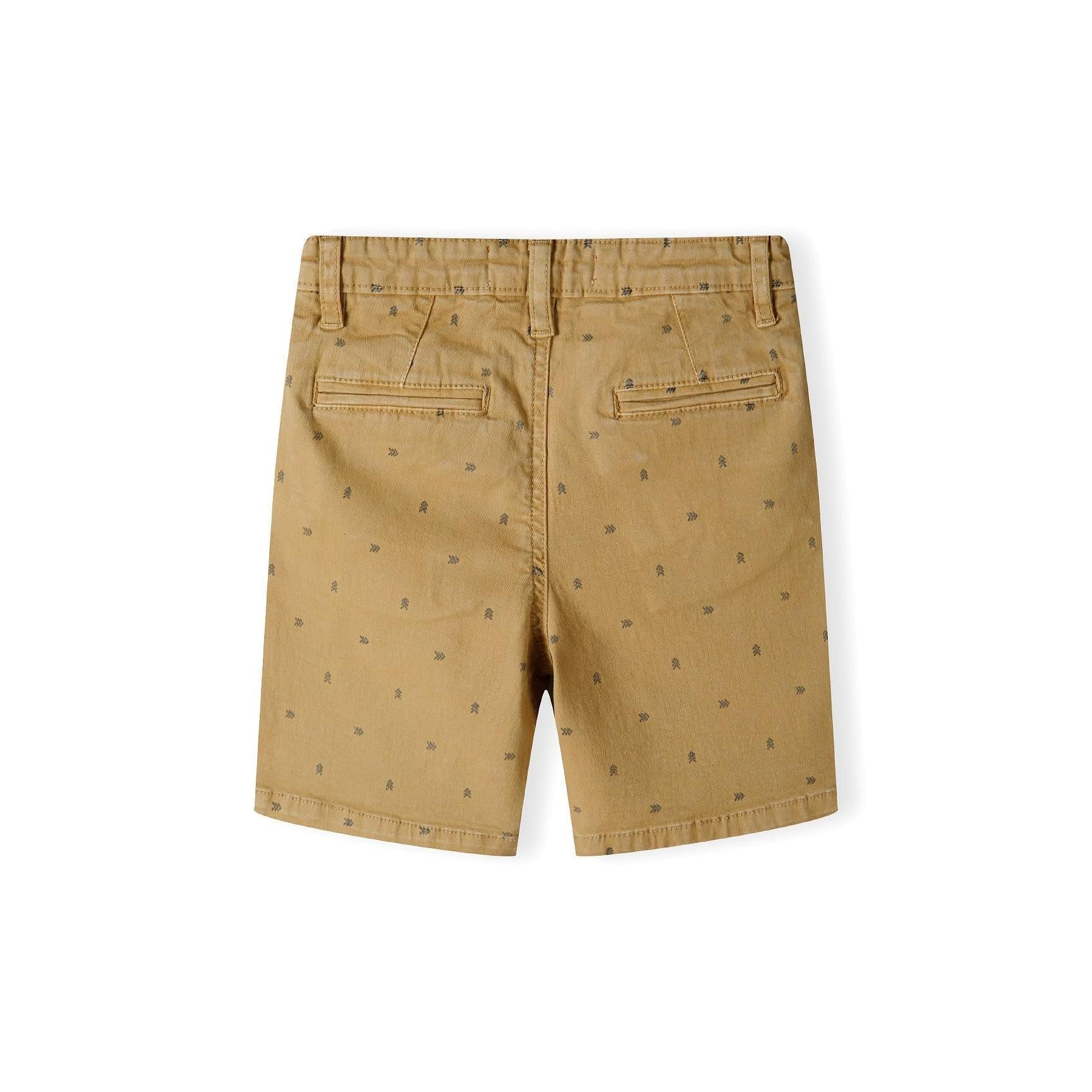 Back view of beige chino shorts with all-over small print pattern and turn-up hems on white background