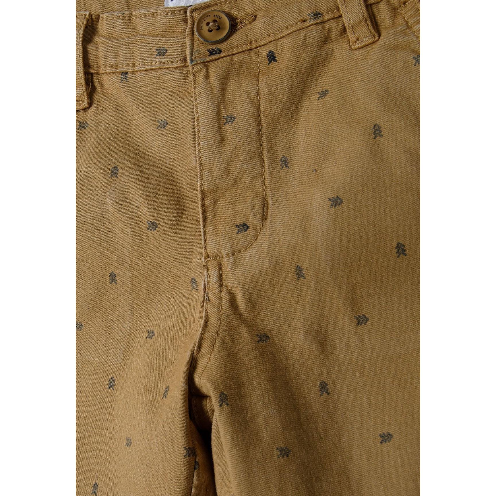 Close-up detail of beige chino shorts showing waistband, button fastening and small arrow print pattern