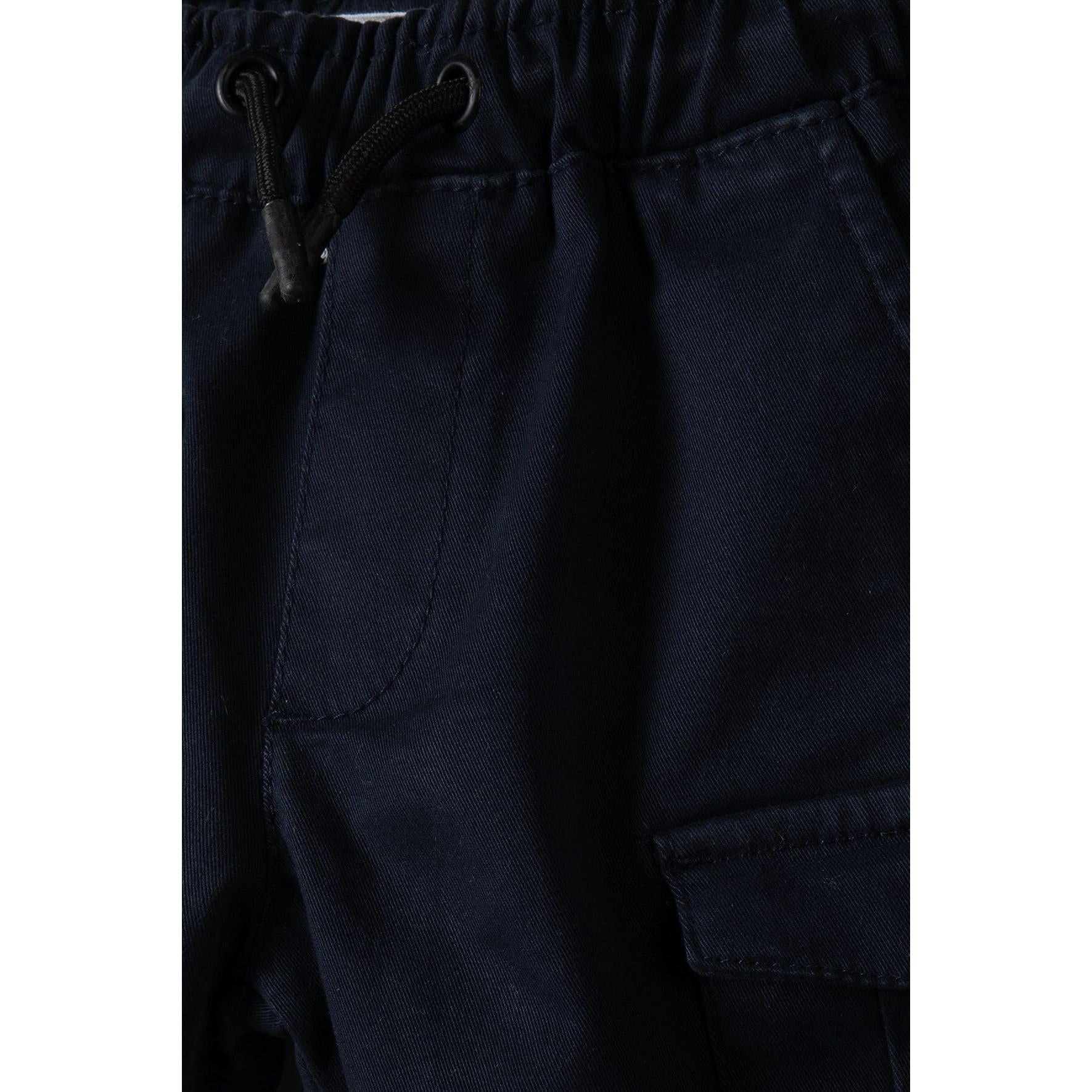 Close-up detail of navy combat shorts showing drawcord ties and cargo pocket construction