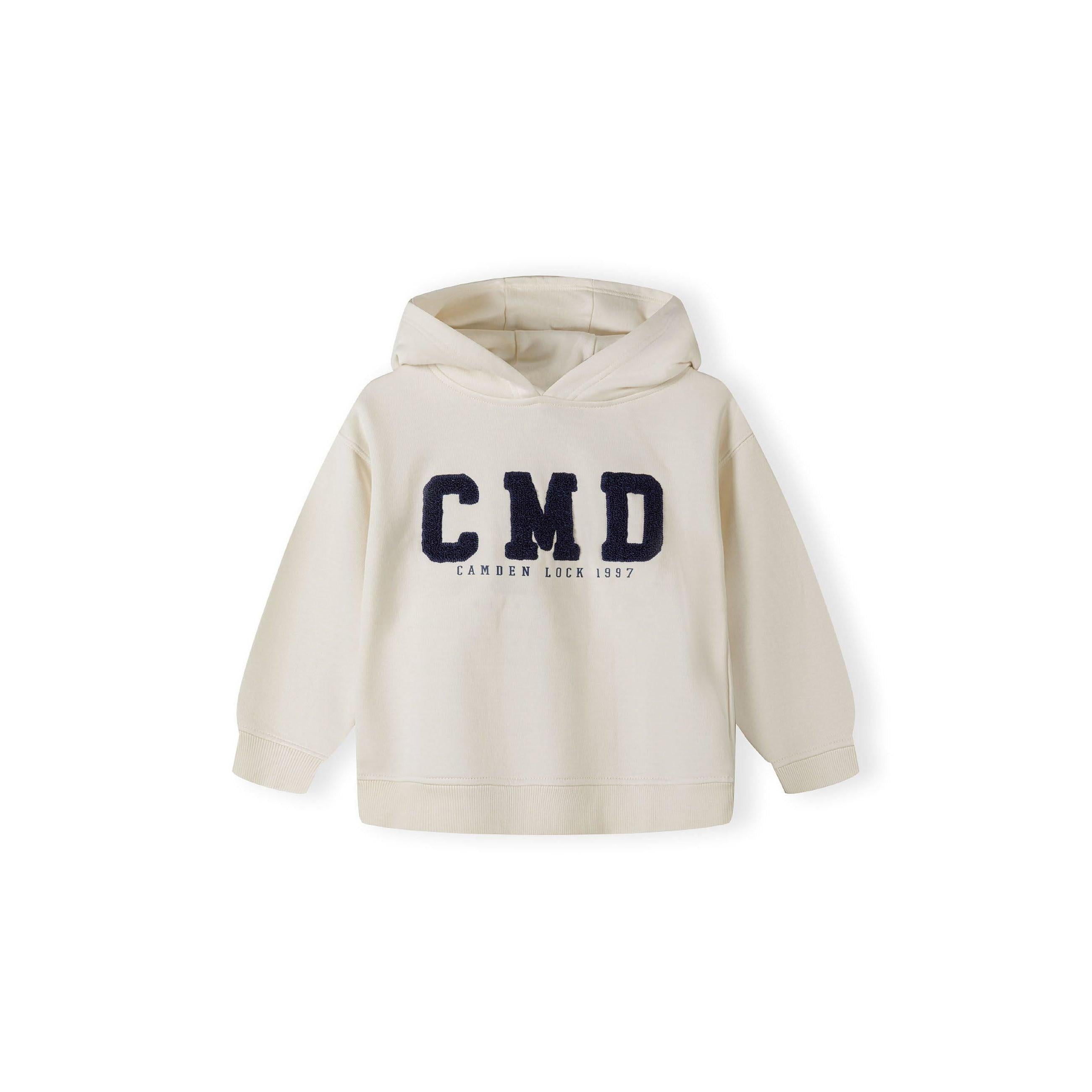 Close-up detail of cream joggers showing large navy blue C boucle embroidery and drawstring waistband