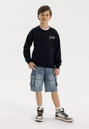 Boys denim cargo shorts with drawcord navy 3-14y, lightweight cotton, featuring large pockets, worn with a black sweatshirt.