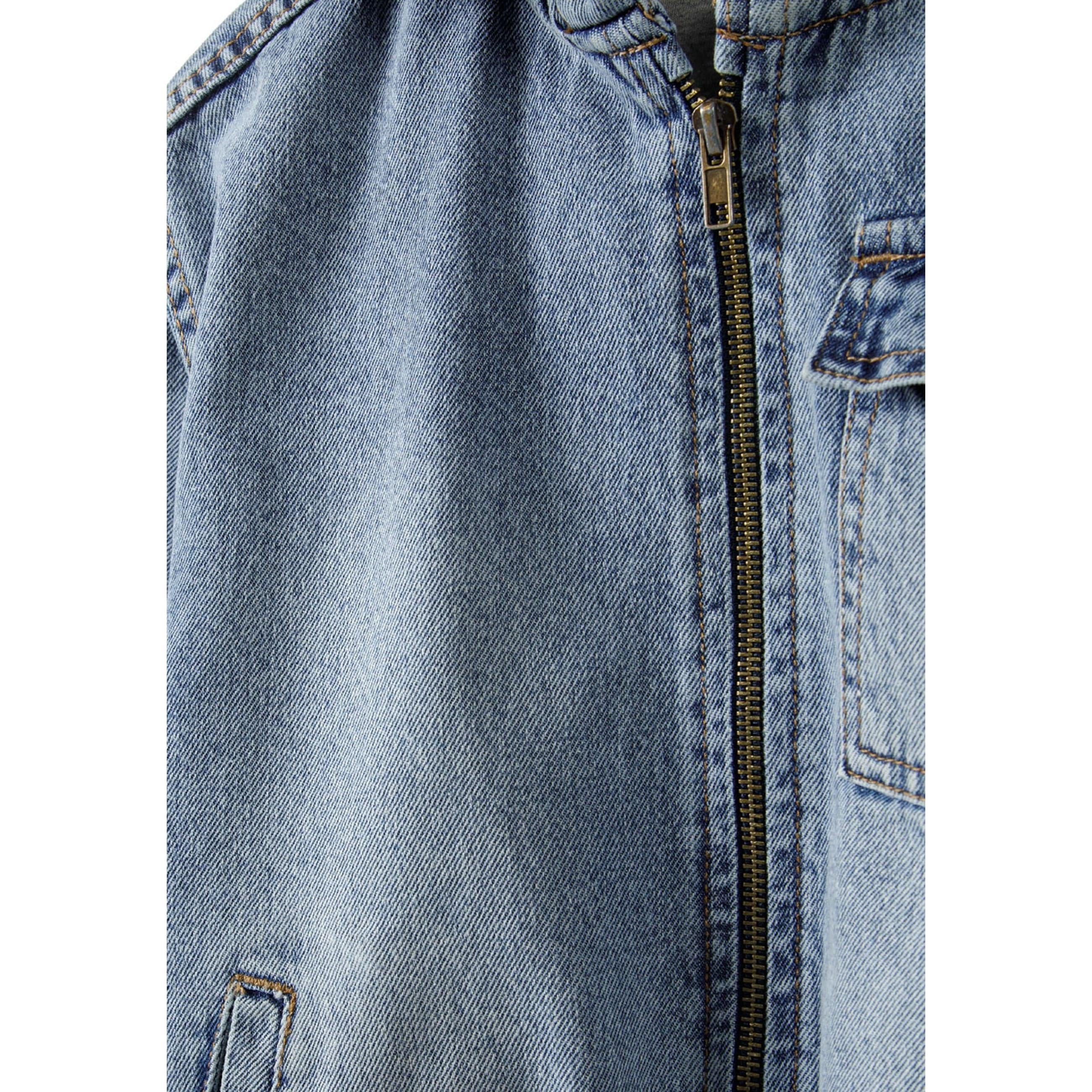 Close-up detail of navy denim fabric texture, metal zip closure and stitching construction