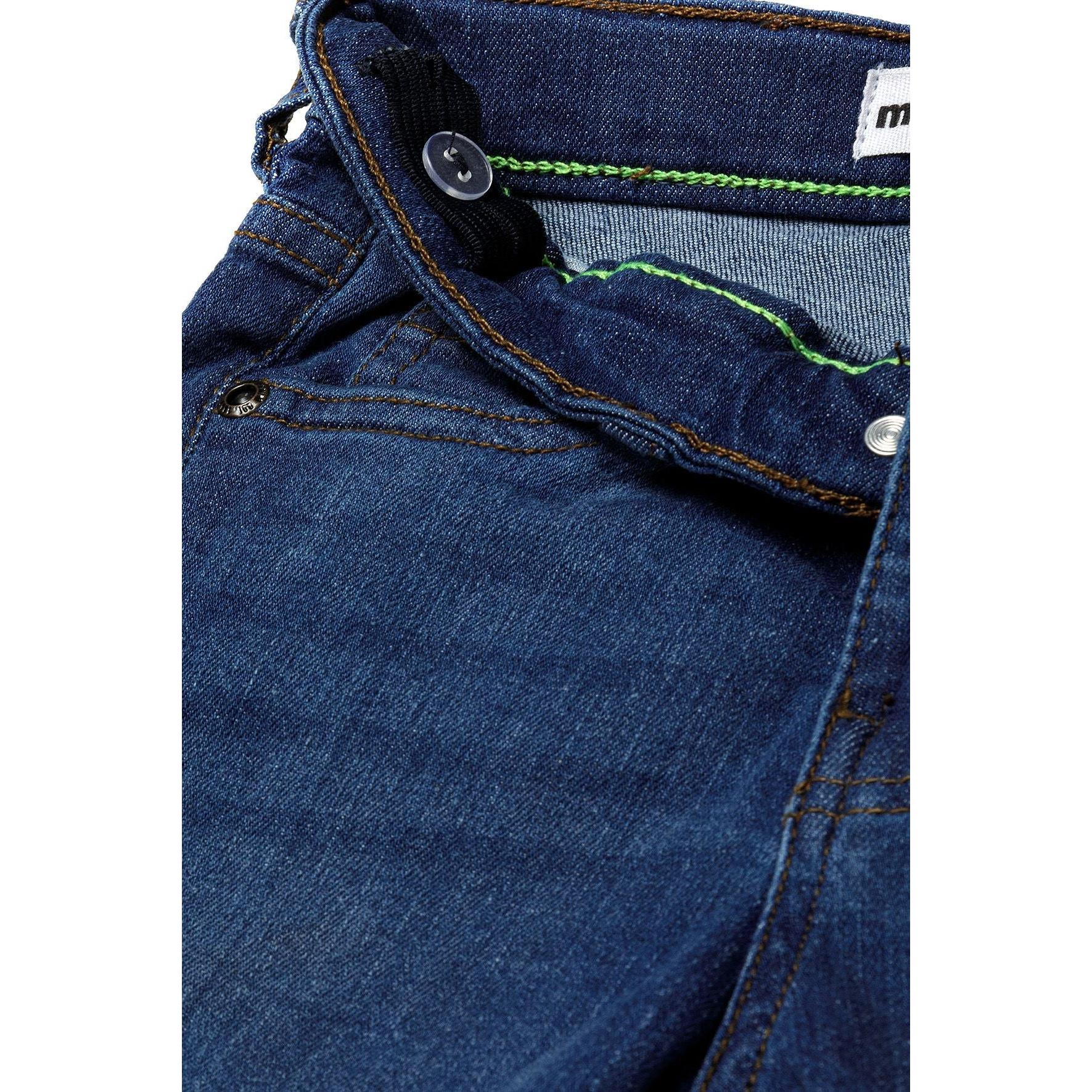Close-up detail of navy denim shorts showing neon green contrast stitching and button closure with Minoti label