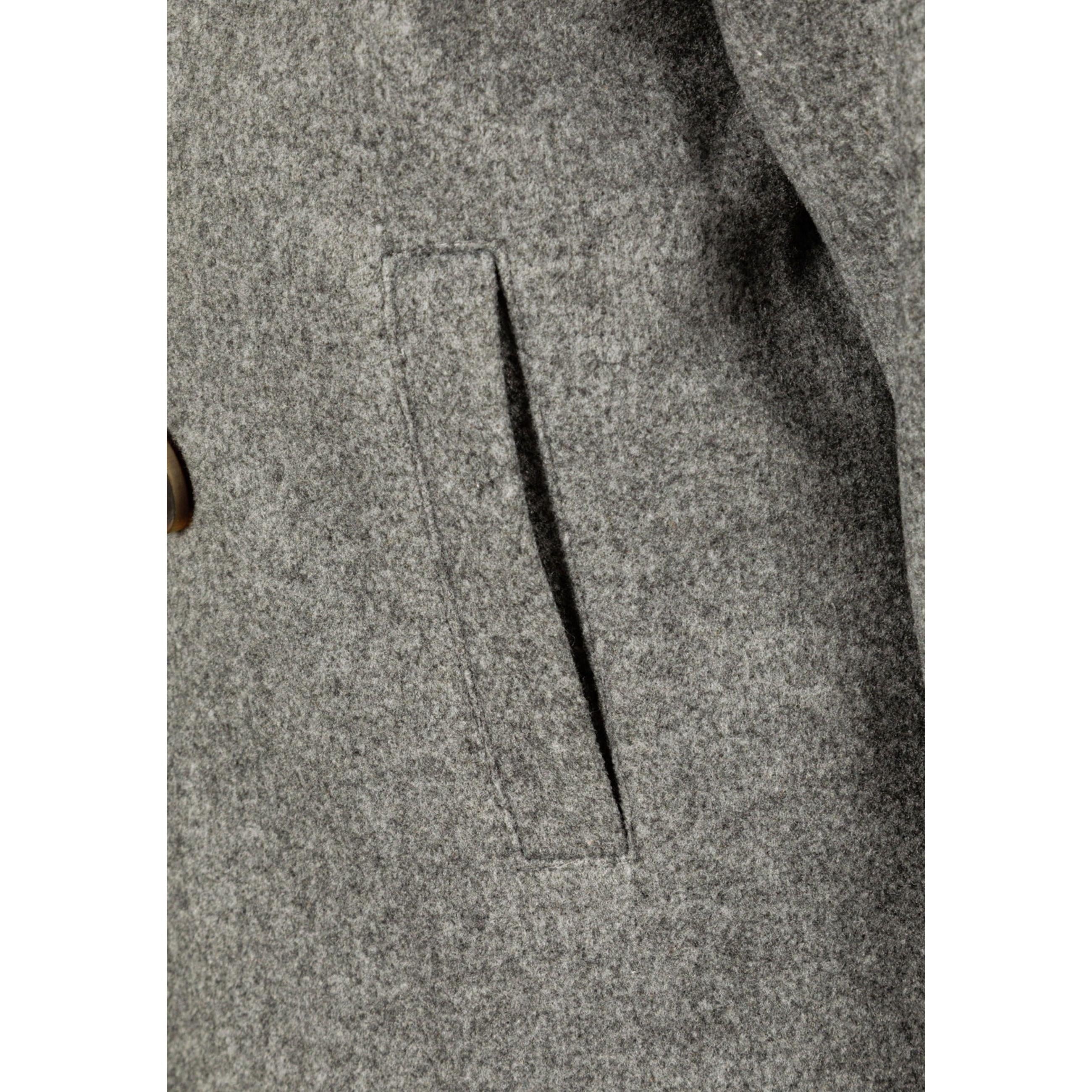 Close-up detail of grey wool fabric texture and functional chest pocket with clean stitching