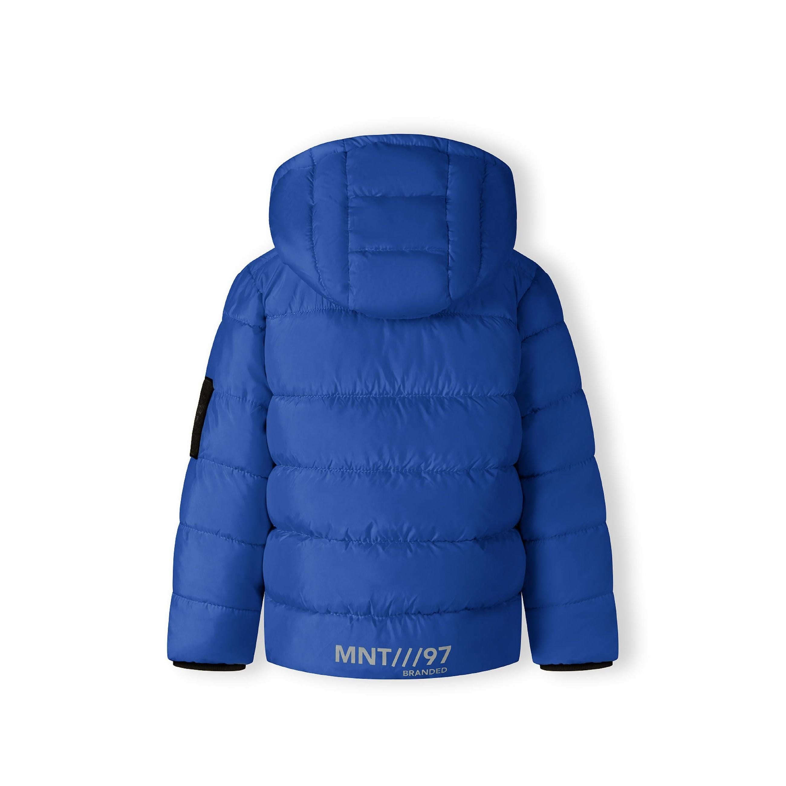 Close-up detail of black fabric label on cobalt blue jacket showing MNT brand text and authenticity information