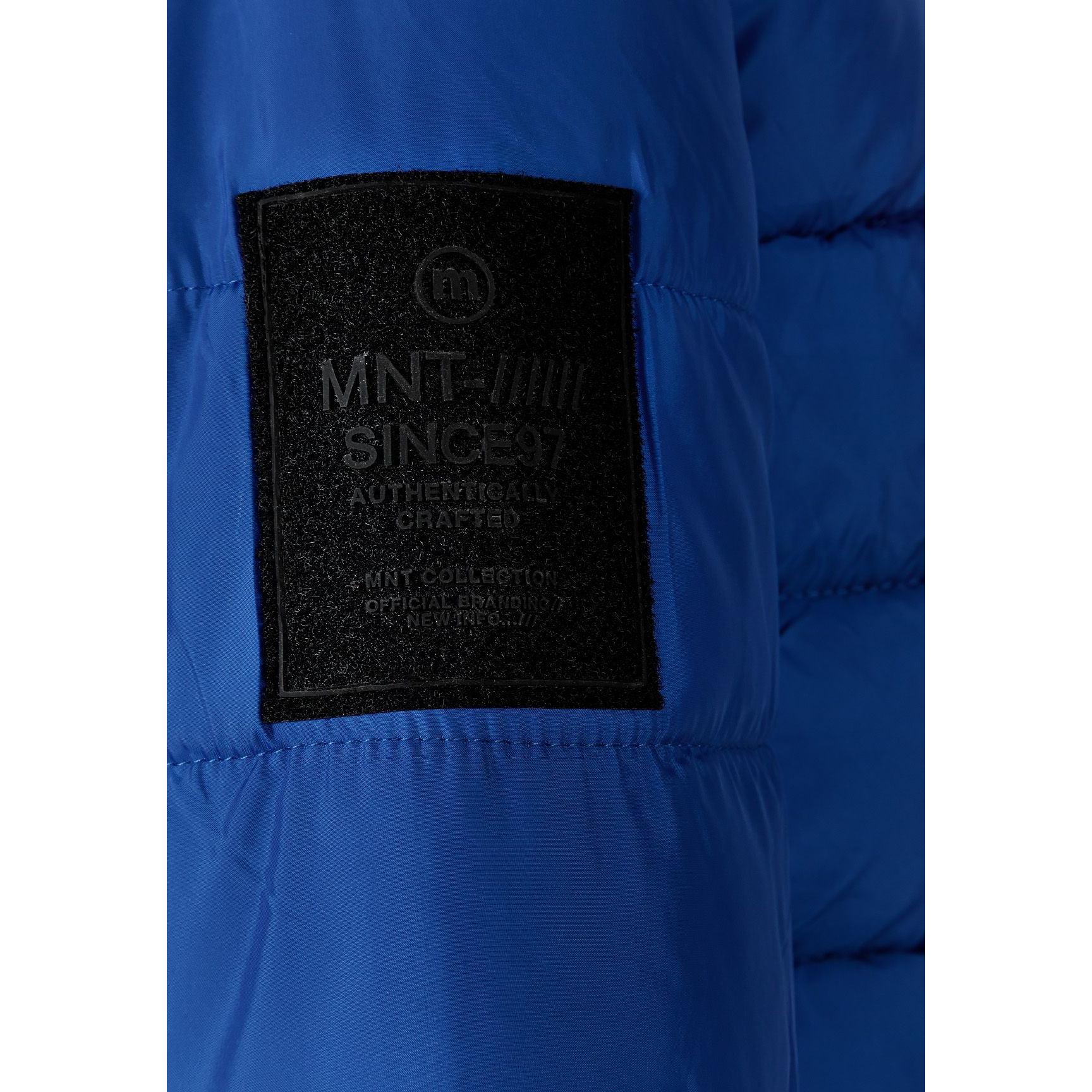 Close-up detail of black fabric label on cobalt blue jacket showing MNT brand text and authenticity information