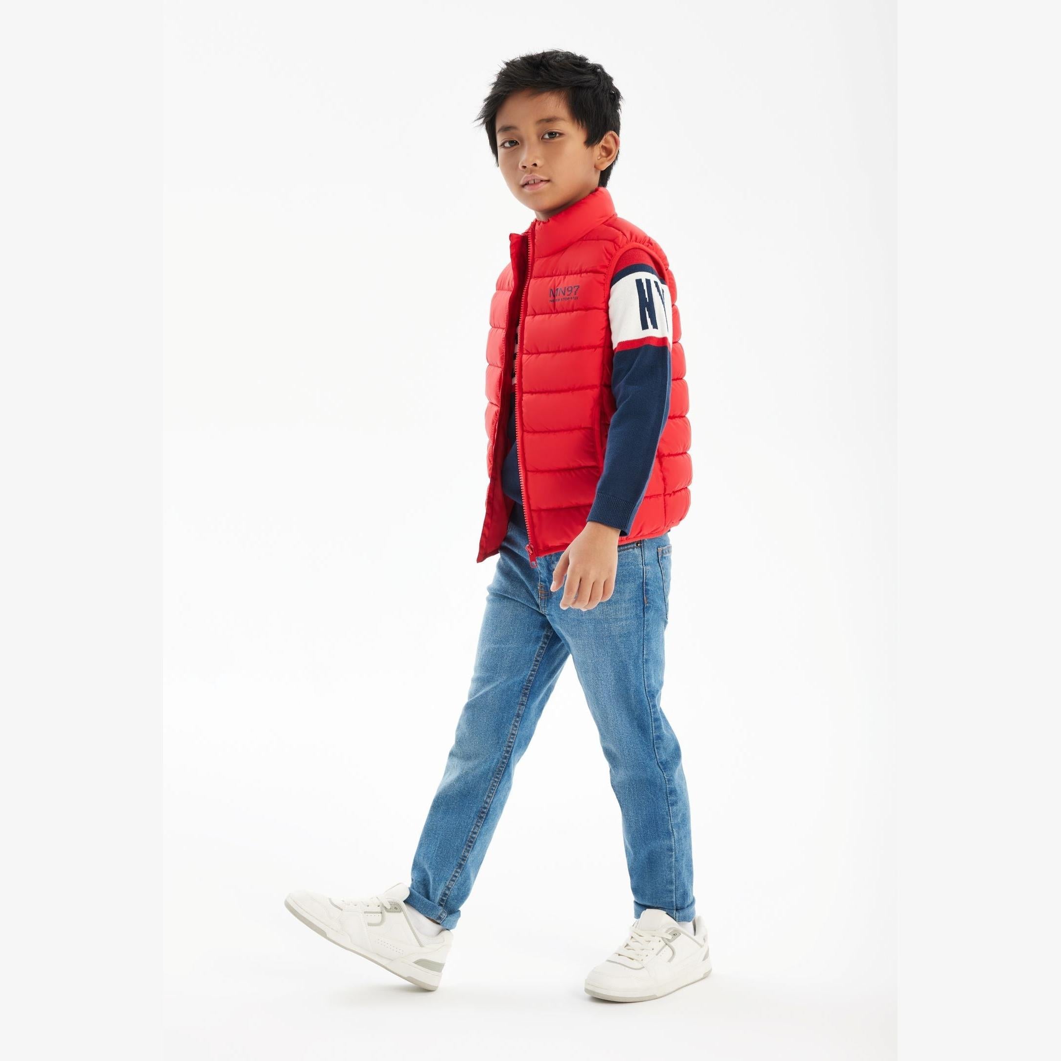 Close-up detail of red gilet showing zip fastening, Minoti label and chest print with contrast trim details