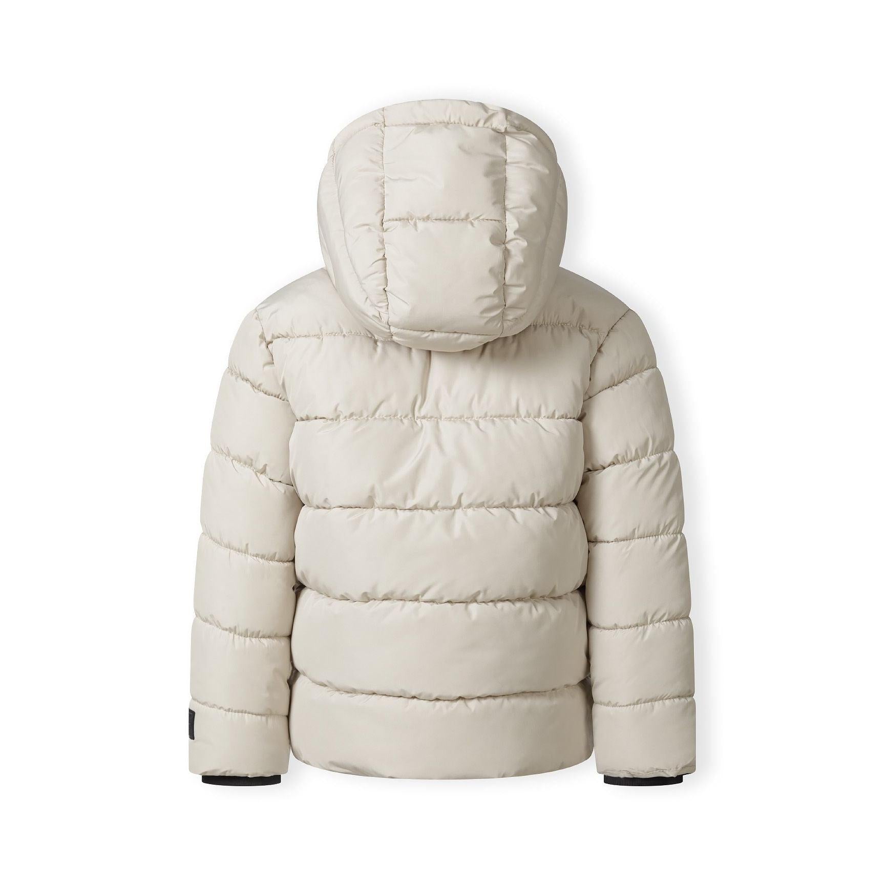 Close-up detail of cream padded jacket showing black branded patch with mountain logo and Minoti text on sleeve