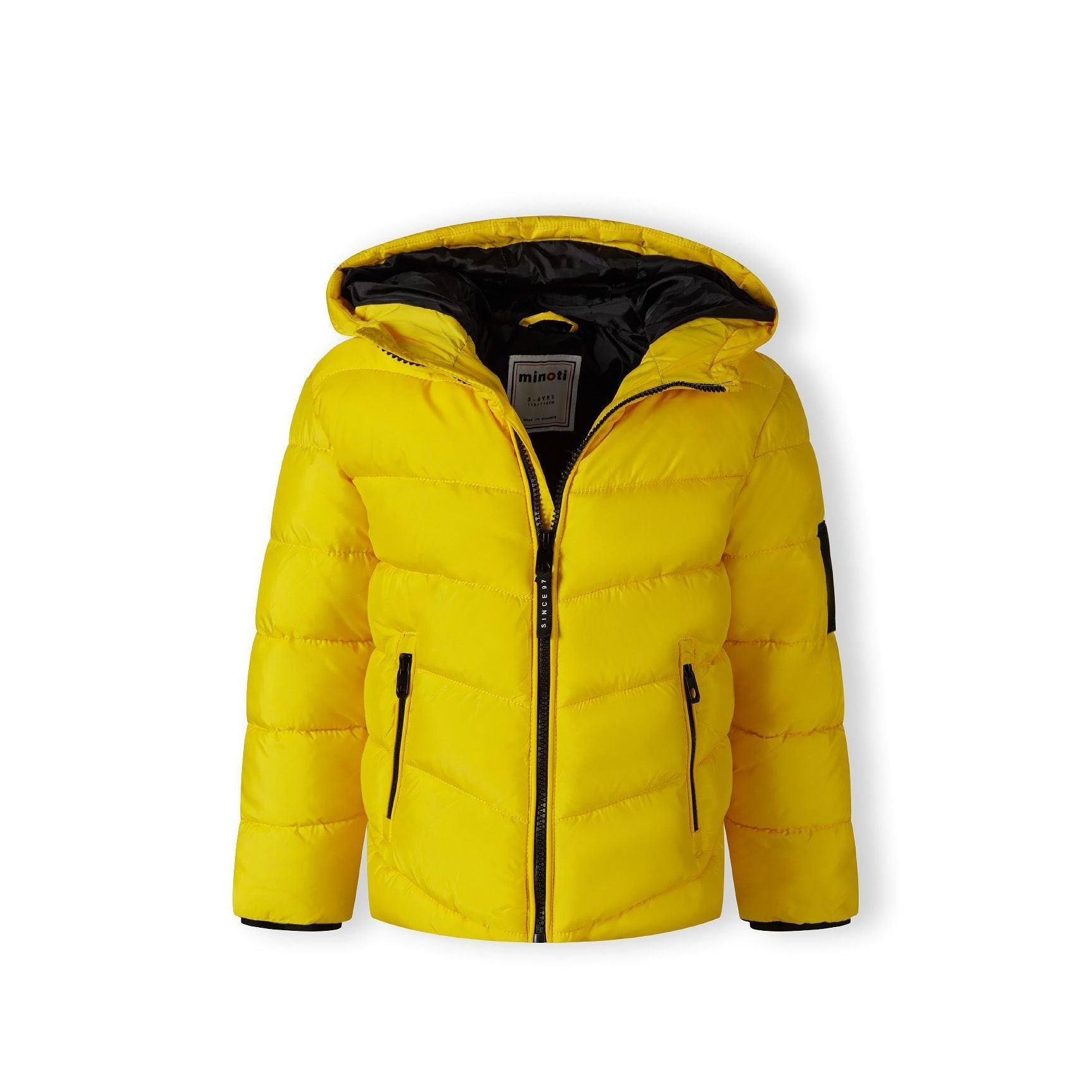 Close-up detail of black fabric label on yellow padded jacket showing Minoti brand text and sizing information