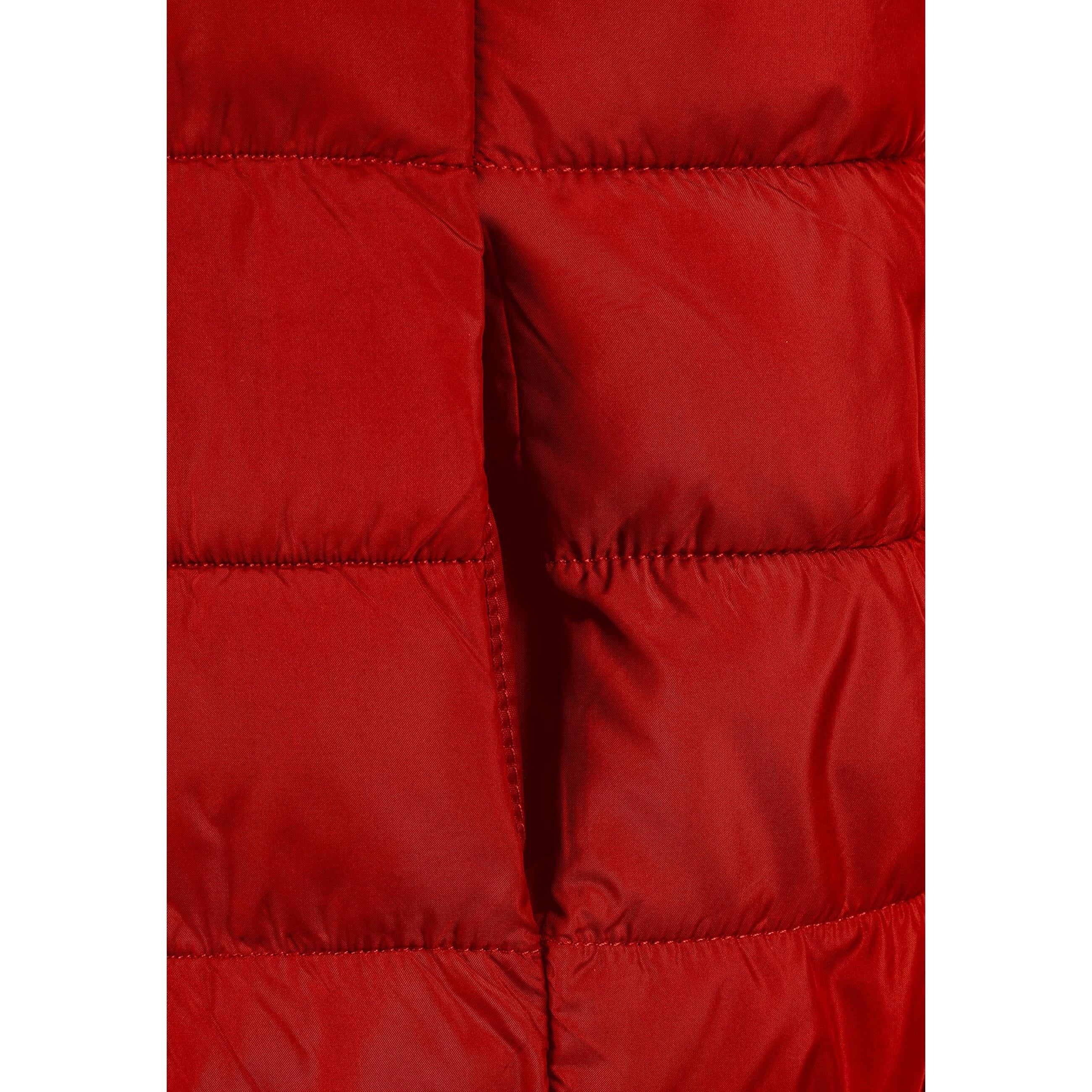 Close-up detail of red padded gilet showing quilted texture, zip fastener and gathered hood construction