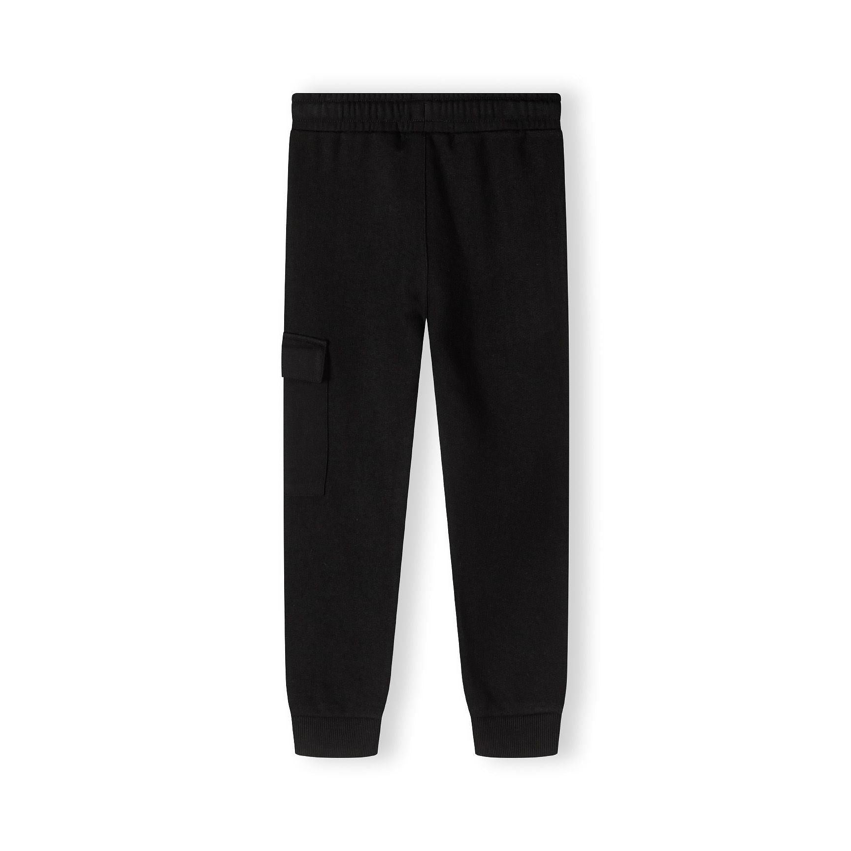 Close up detail of black fleece joggers showing drawstring waistband and green label patch