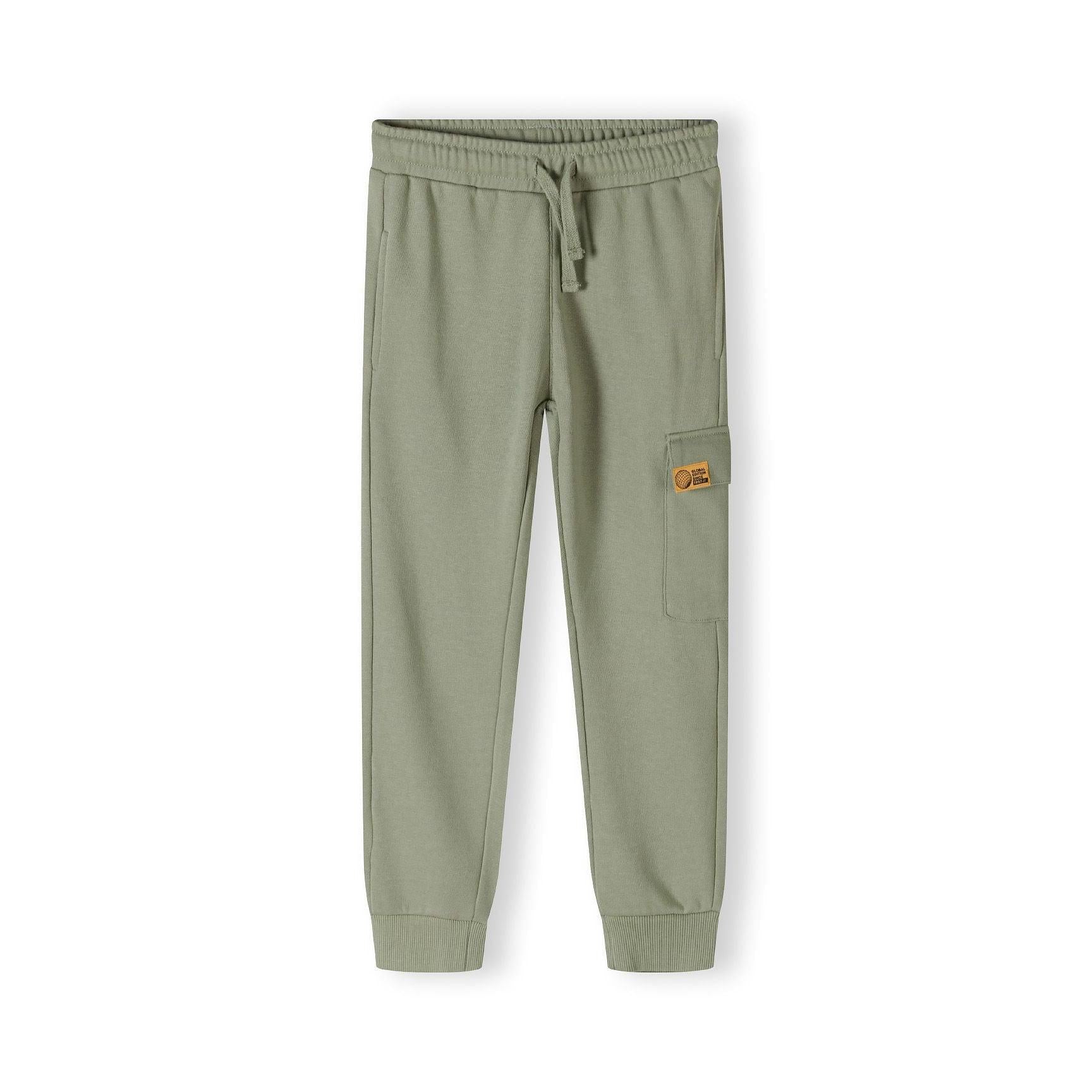 Close-up of olive green fleece joggers showing drawstring waist detail and orange logo patch on leg