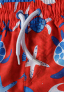 Boys swim shorts all-over print red 9m-8y featuring adjustable drawstring waist, vivid red color, and colorful turtle patterns.