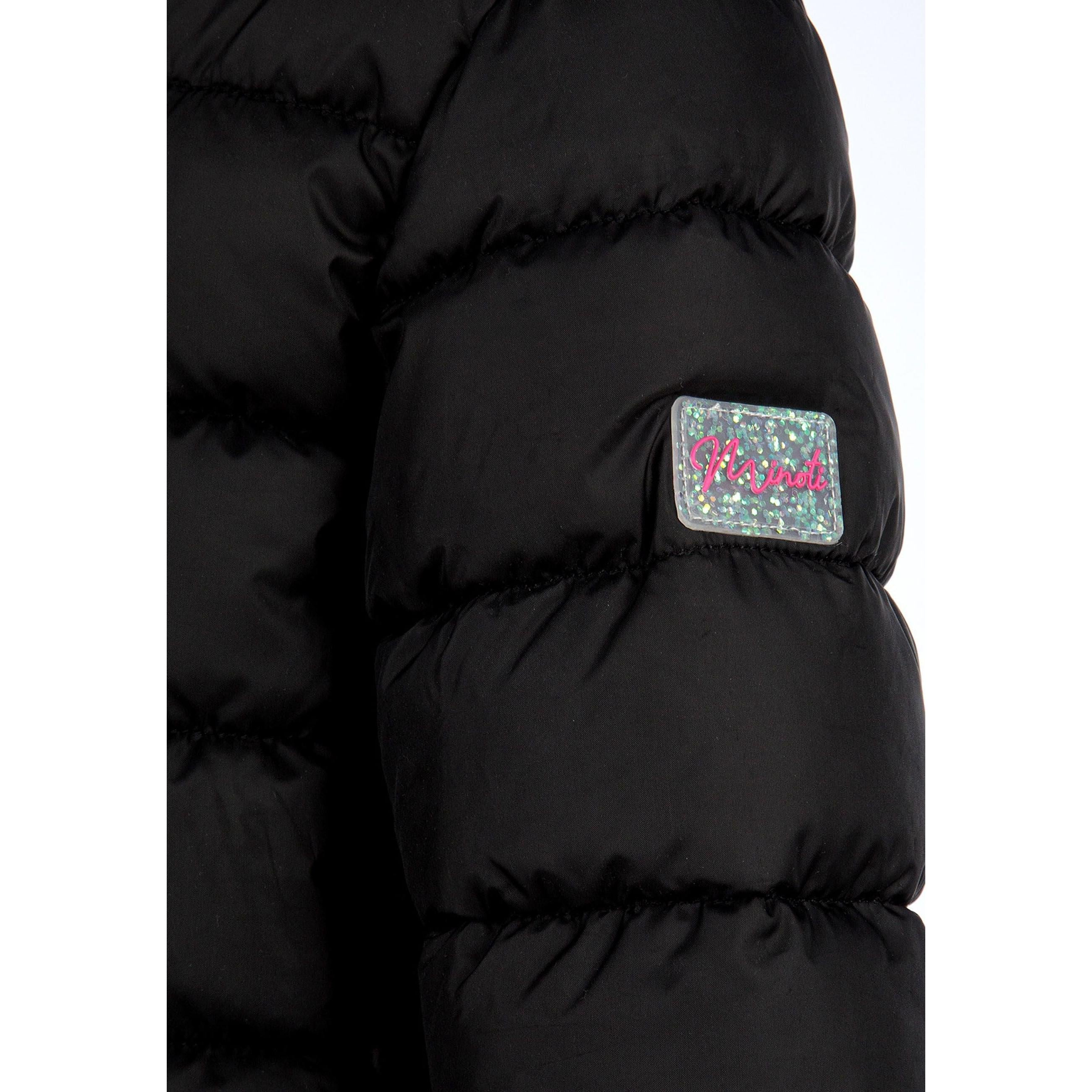 Close-up detail of black quilted fabric texture with zip fastening and hood construction