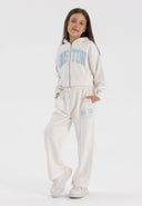 Girls cropped zip through hoodie and wide leg jogger set cream 3-14y with hood, kangaroo pocket, and printed detail. Comfortable cotton fleece.
