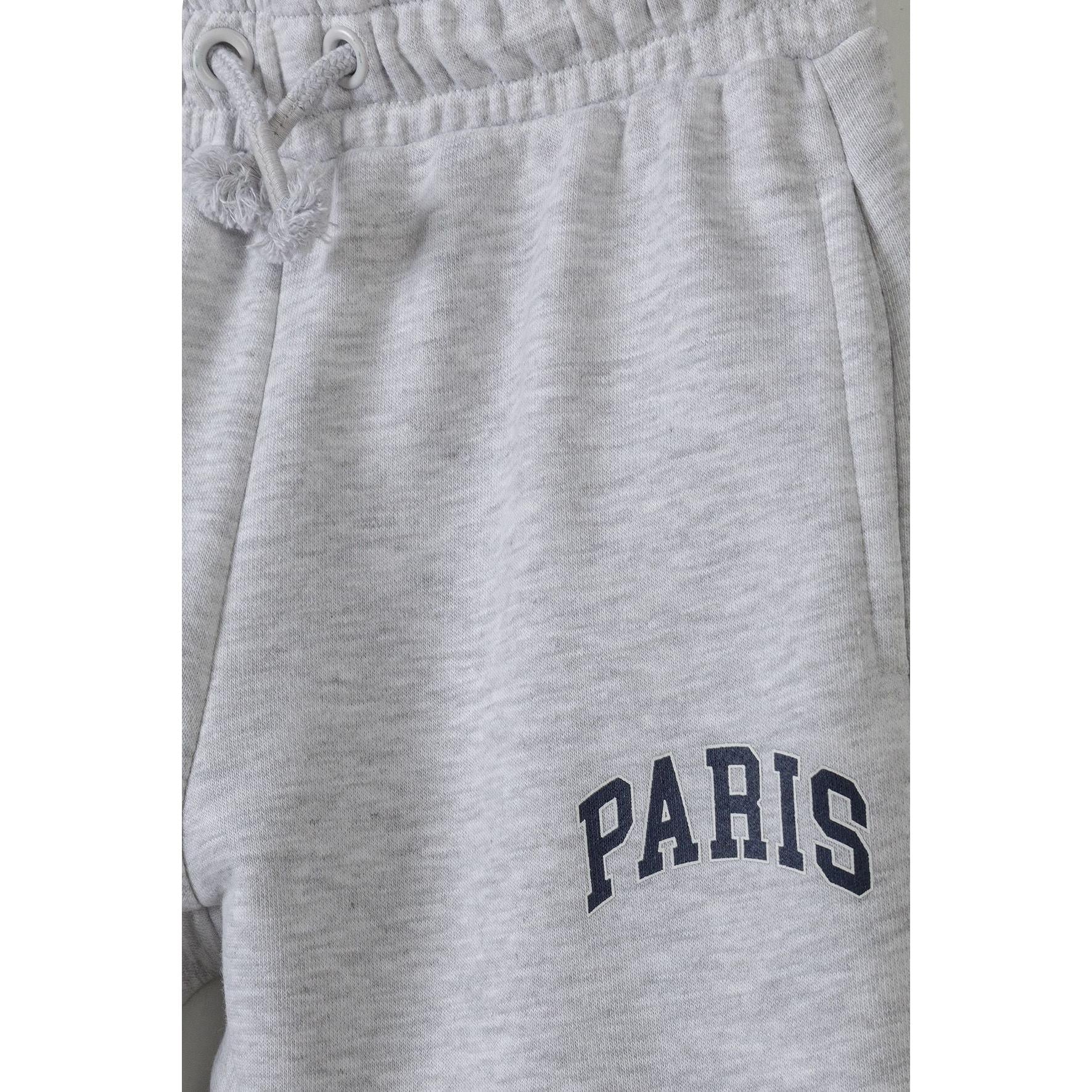 Close-up detail of grey fleece fabric texture with Paris text print in navy blue lettering and drawstring waistband
