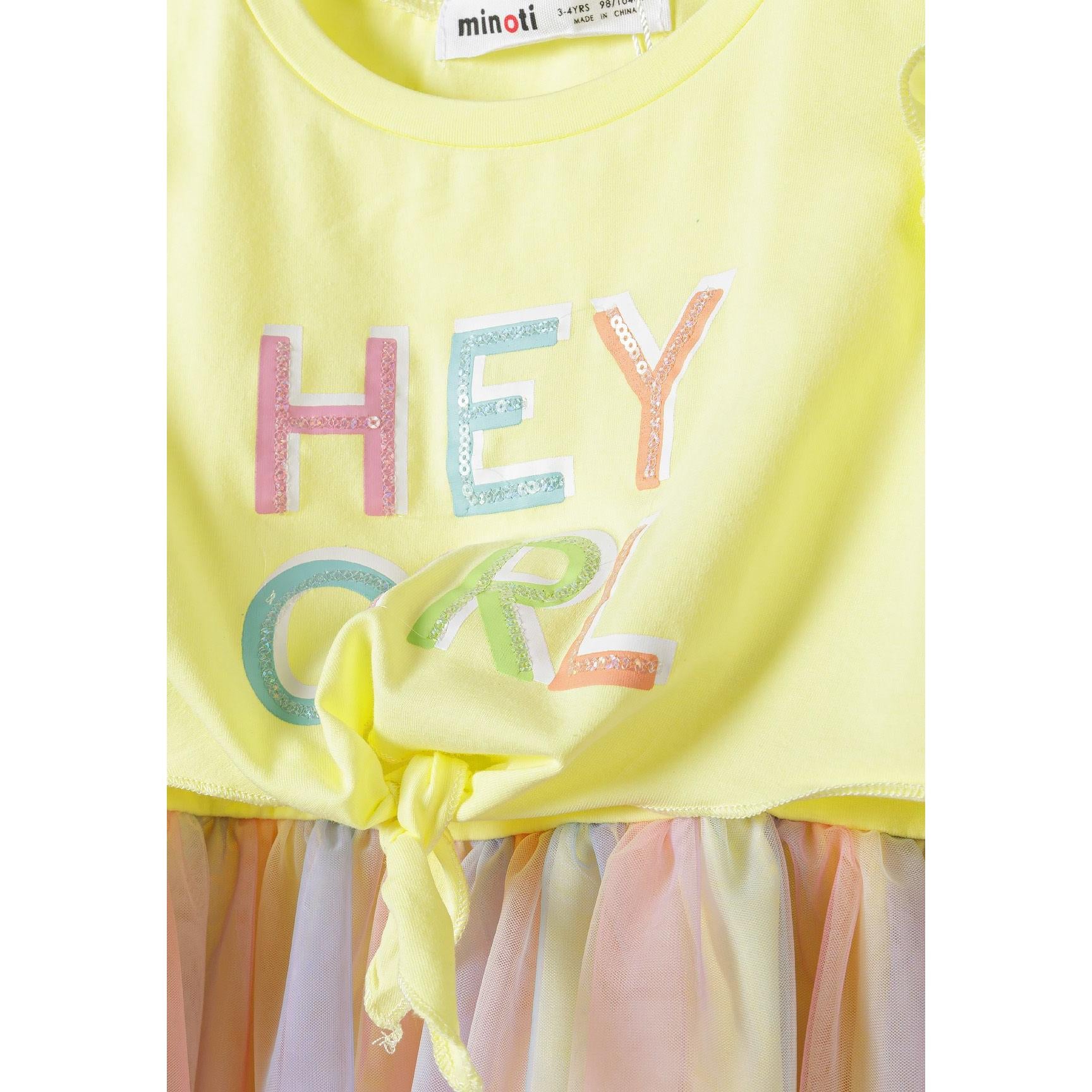 Close-up front view showing sparkly rainbow colored 'HEY GIRL' text print on yellow jersey bodice with Minoti label visible at neckline