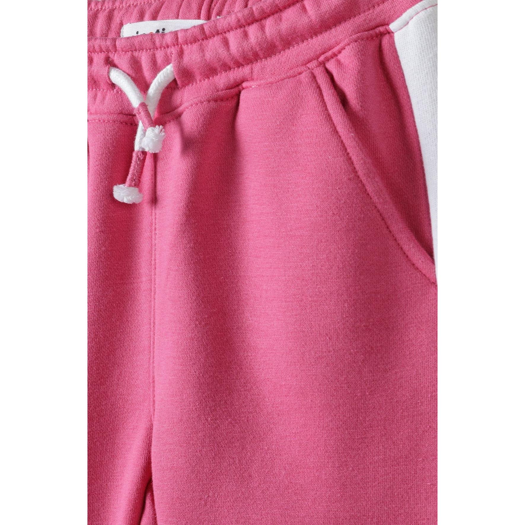 Close-up detail of pink sweatpants waistband showing white drawstring ties and front pocket construction