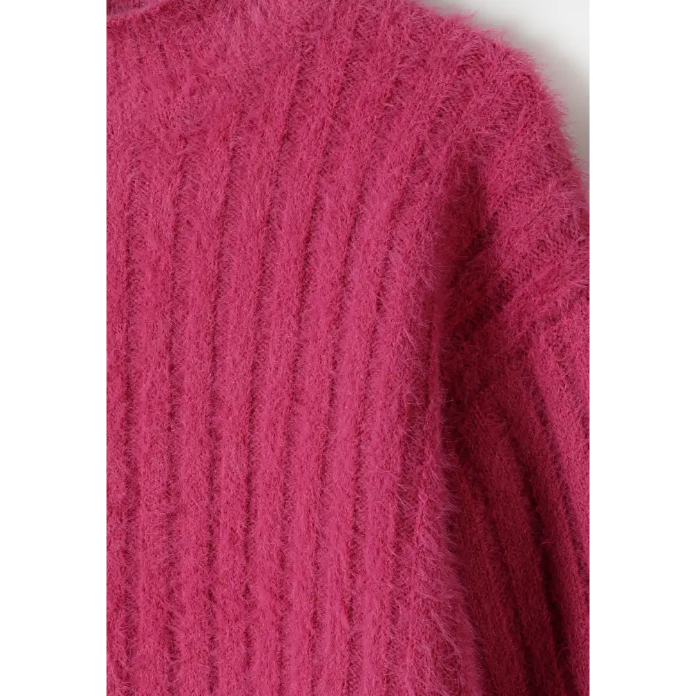 Close-up detail of pink fluffy knit fabric showing soft textured weave and ribbed pattern