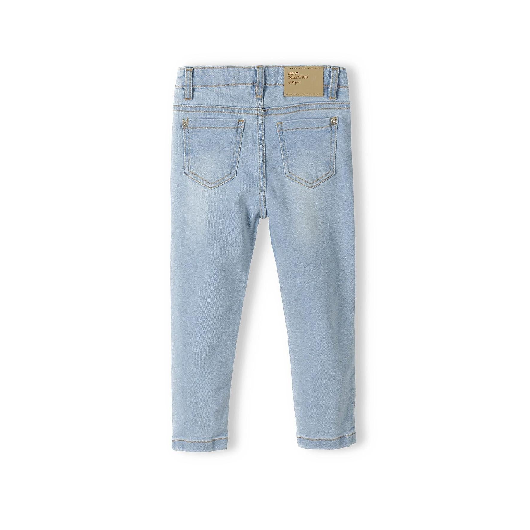 Back view of light blue skinny jeans on white background showing back pockets and brown leather patch label