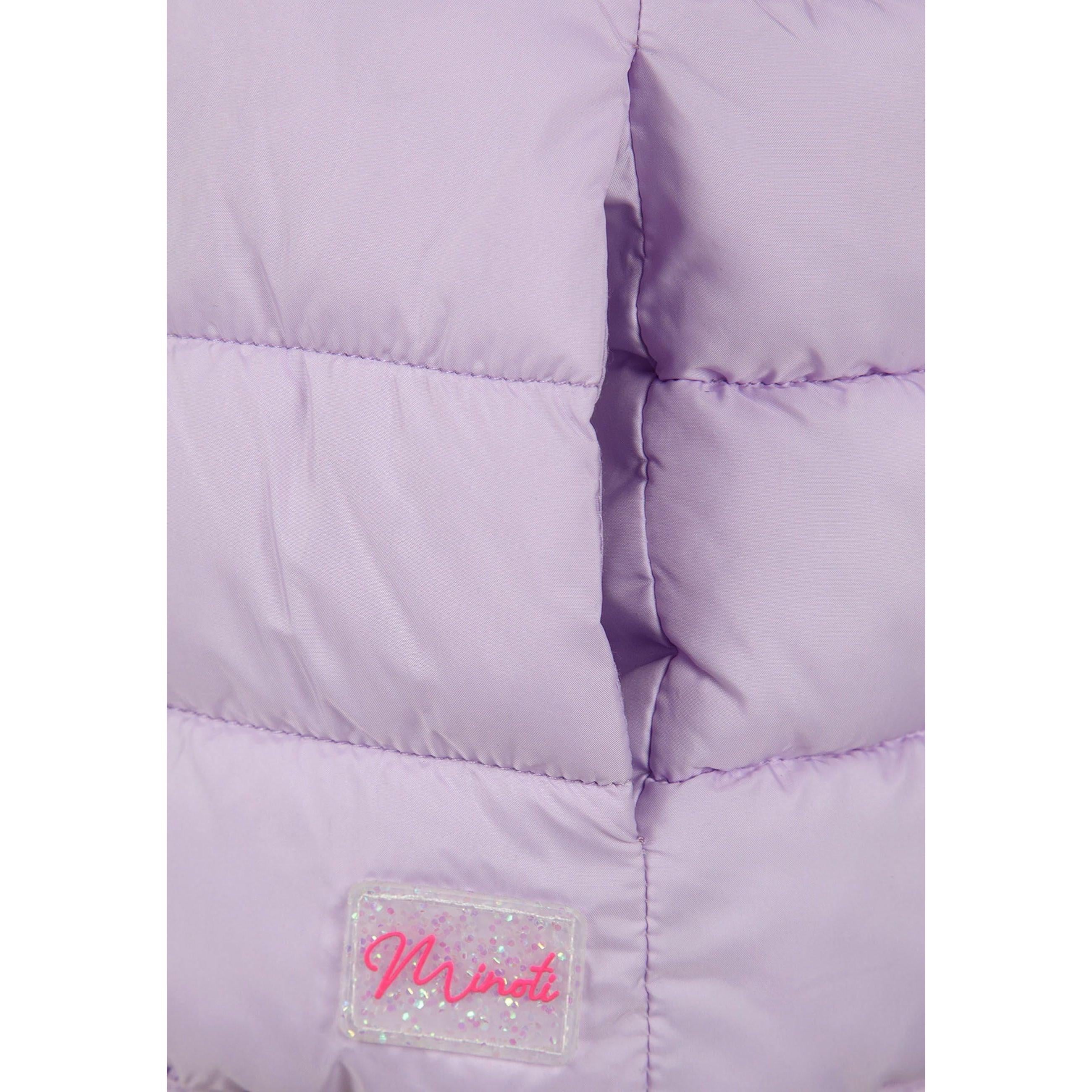 Close-up detail of lilac quilted fabric texture showing stitching pattern and Minoti brand label with glitter finish
