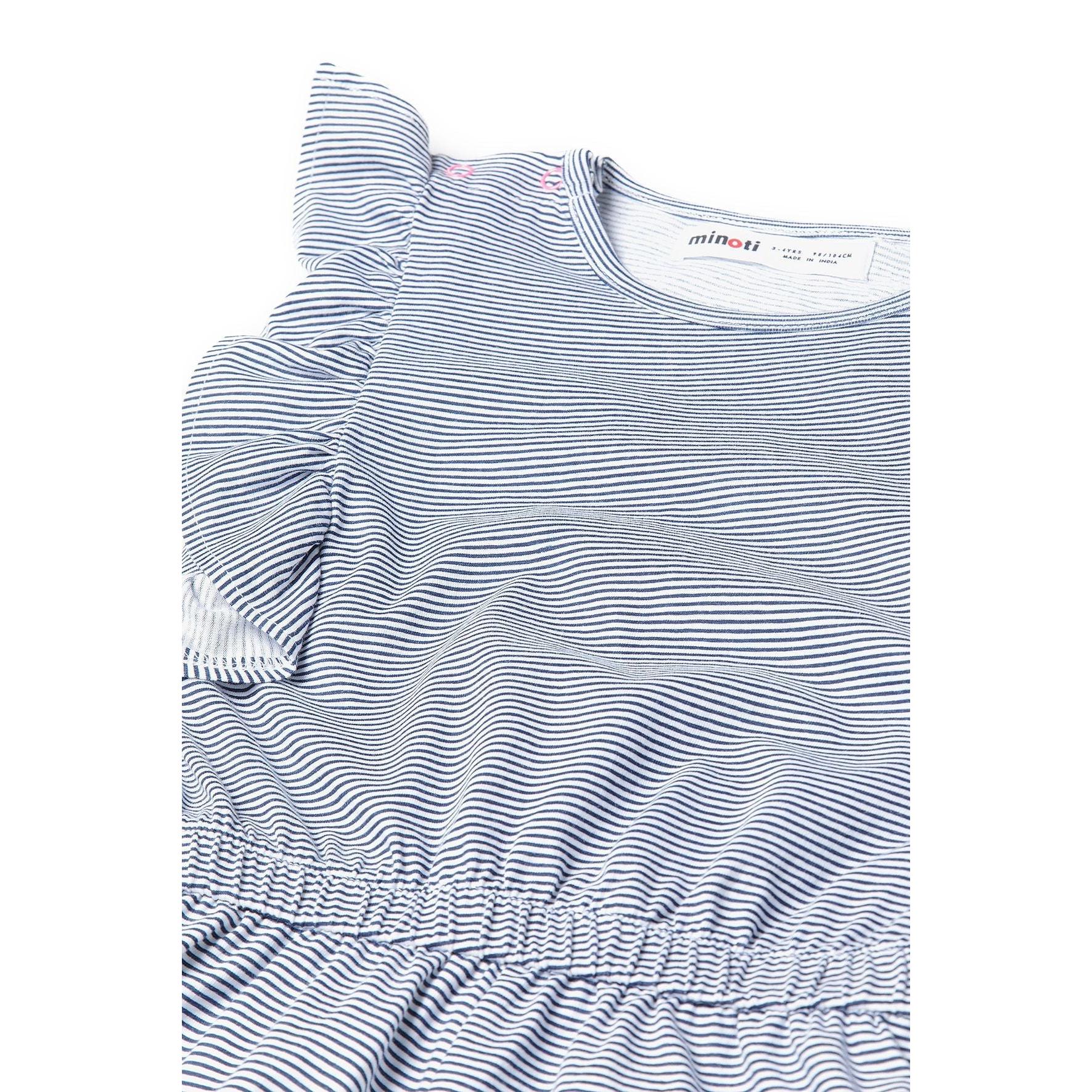 Close-up detail of Minoti label and frill sleeve construction on navy and white striped fabric showing texture and quality