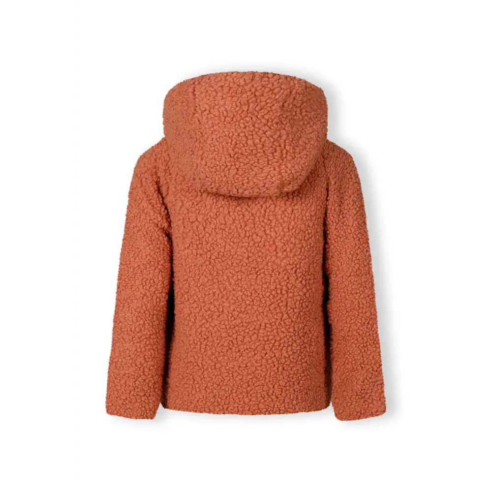 Close-up detail of coral orange teddy fleece fabric showing soft textured surface with fluffy pile