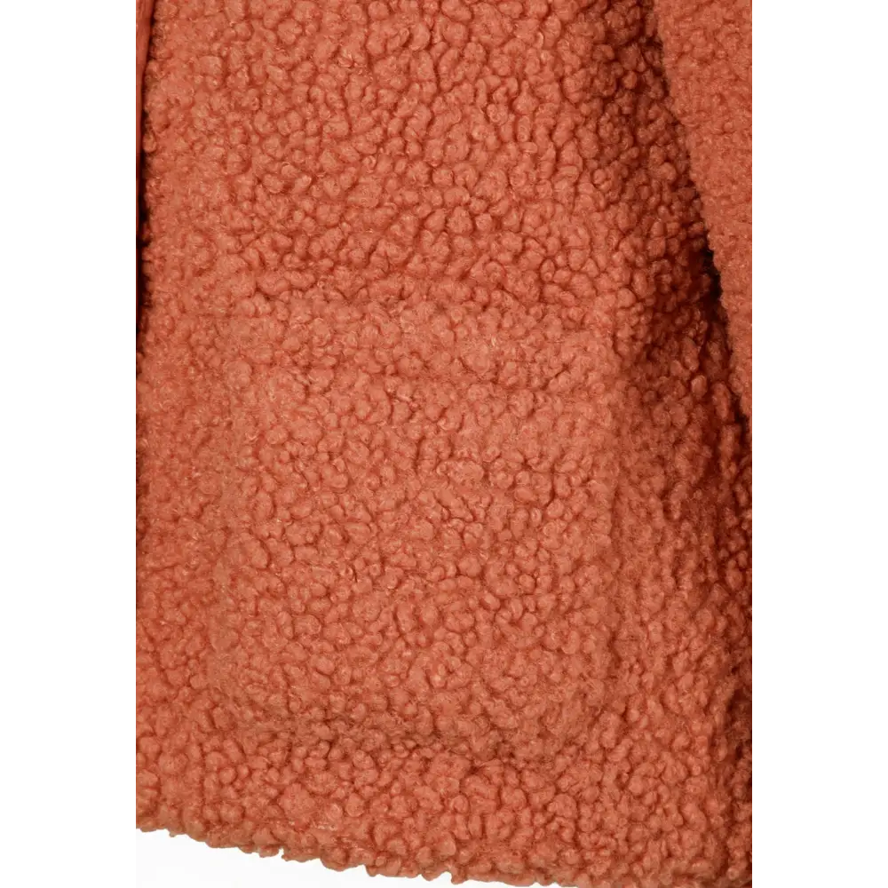 Close-up detail of coral orange teddy fleece fabric showing soft textured surface with fluffy pile