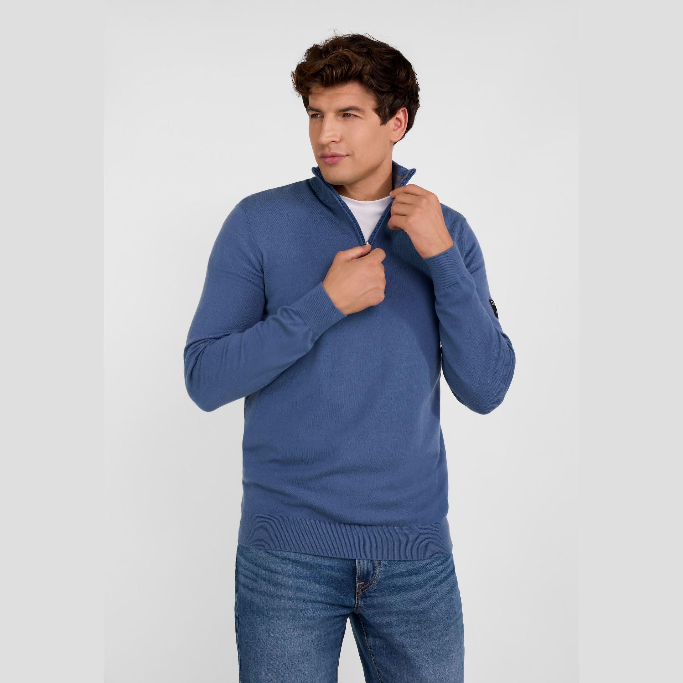 Men's blue half-zip stand collar jumper in a breathable viscose blend, worn with jeans.
